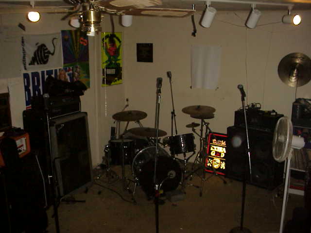 The Mice practice room — drums, amps, banners